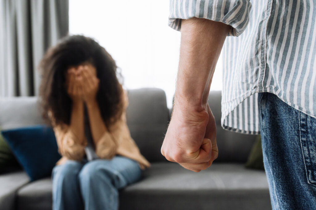 man with clenched fist walking towards a woman