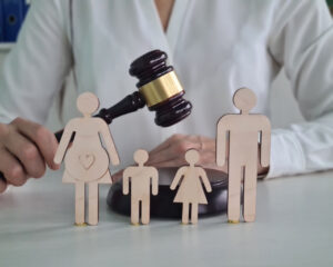 Judge gavel wooden figurines of husband, wife and child children of family in acourthouse during a court session
